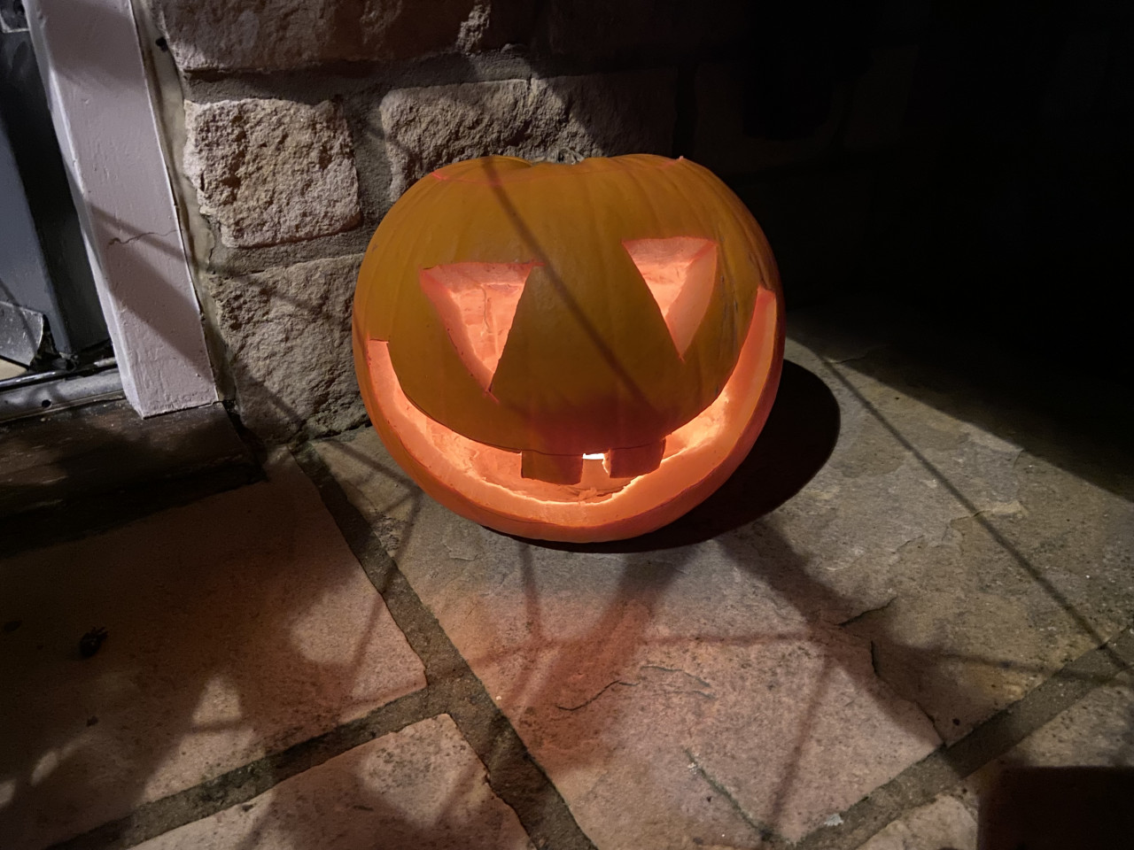 Pumpkin with a goofy looking face carved into it.